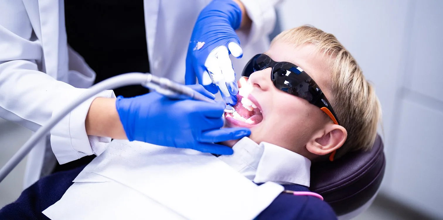 Child receiving a dental check-up wearing protective glasses at New Gisborne Dental House